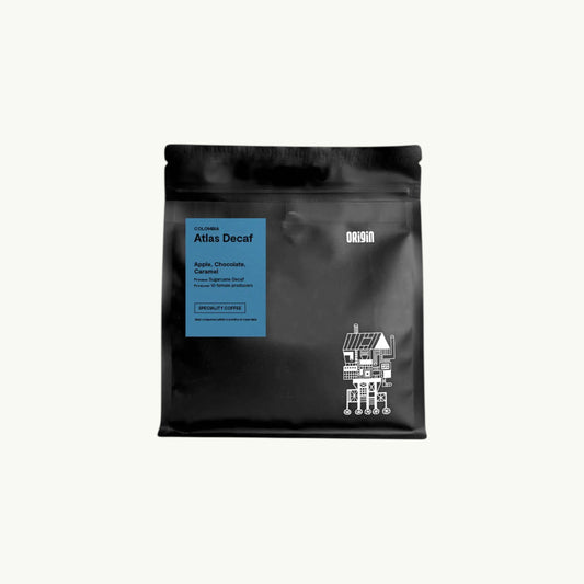 BRiMM Atlas Decaf whole bean coffee in a black bag with a blue label featuring tasting notes of apple and chocolate.