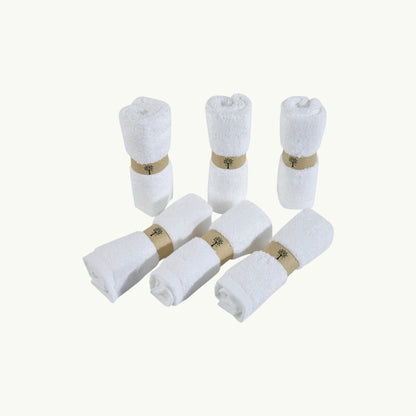 Re:gn set of six white organic bamboo face cloths rolled and secured with eco-friendly paper bands