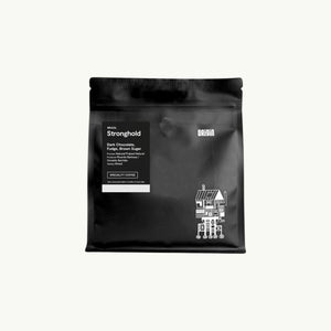 Origin Coffee Stronghold whole bean coffee in a matte black resealable bag with white label and graphic illustration