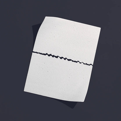 The Lab Co white laundry detergent strip with a perforated center line for easy tearing on a dark grey background