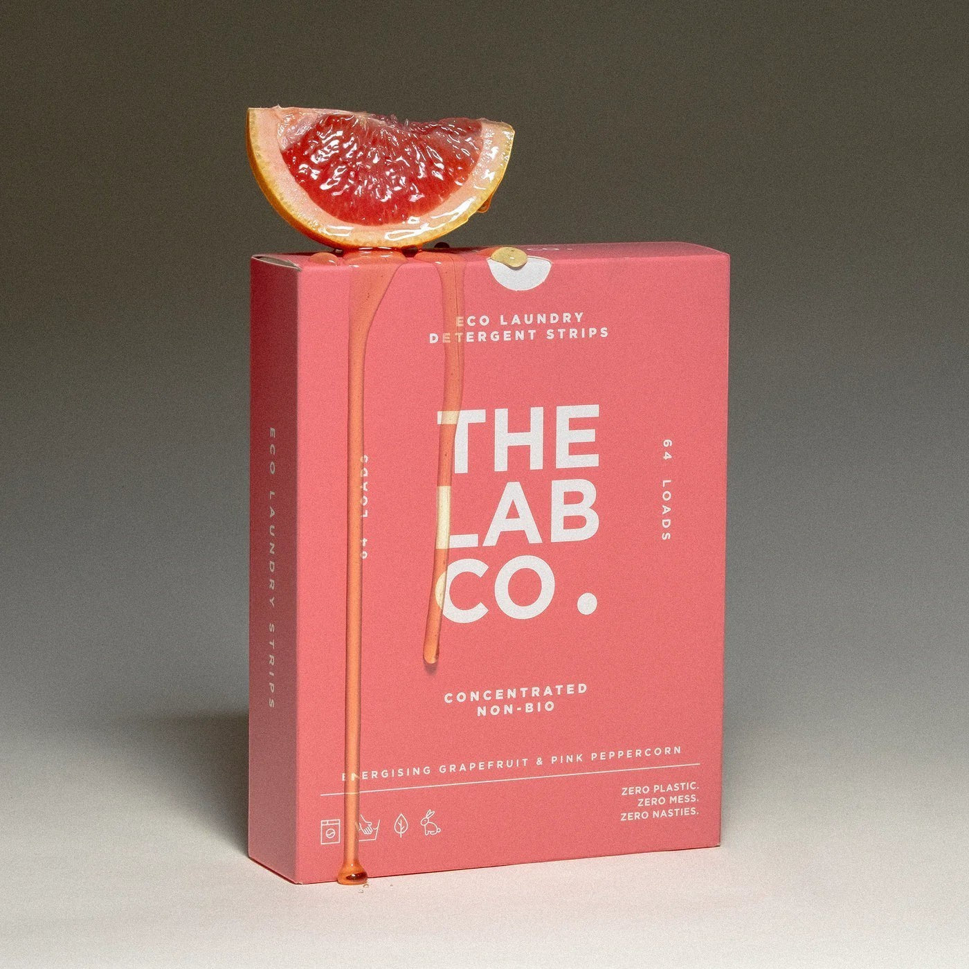 The Lab Co. Energising Laundry Detergent Strips in a pink box topped with a fresh grapefruit slice.