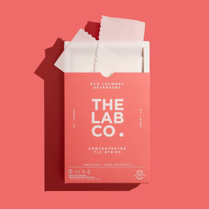 The Lab Co. Energising Laundry Detergent Strips in a pink plastic-free box with one strip partially removed.