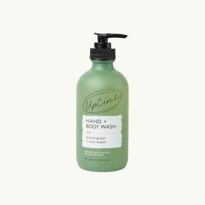 UpCircle Hand & Body Wash in a frosted green glass bottle with a black pump, featuring lemongrass and kiwi fruit water.