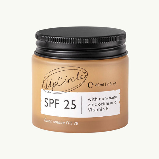 UpCircle SPF 25 mineral sunscreen in a 60ml amber glass jar with a black lid, featuring zinc oxide and raspberry oil.