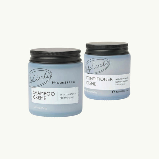 BRiMM UpCircle shampoo and conditioner crème jars with blue frosted glass and black lids on a light background