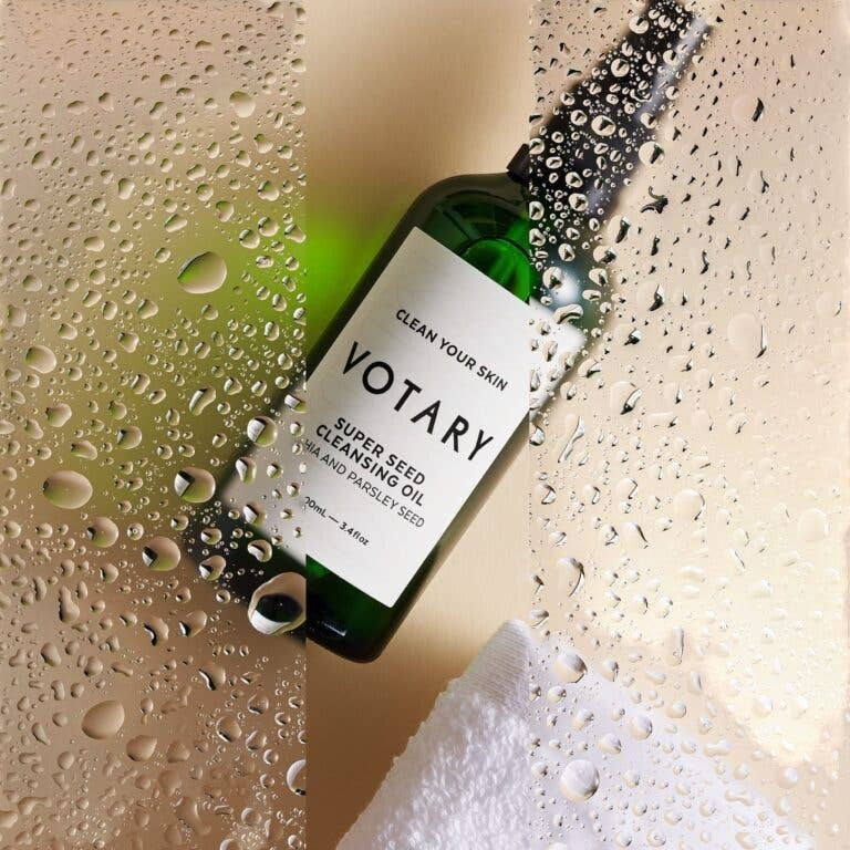 votary Super Seed Cleansing Oil bottle on a wet surface with a white flannel, ideal for gentle makeup removal.